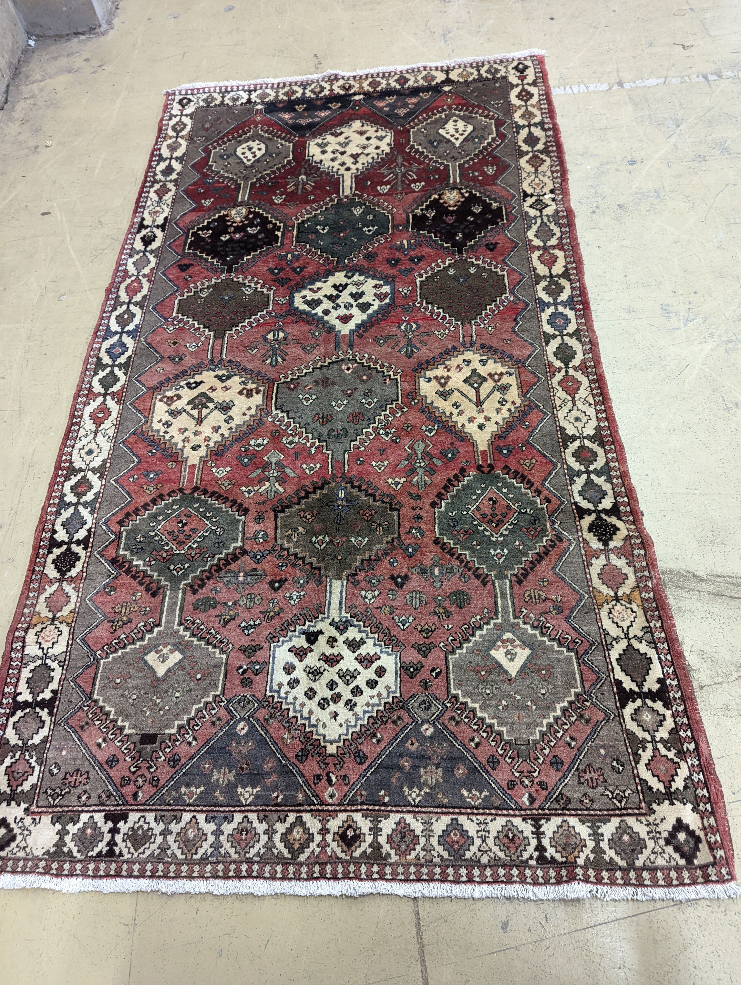 A Persian Shiraz red ground rug, 280 x 150cm